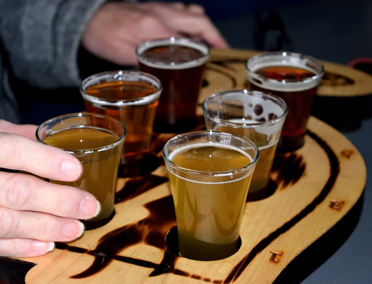 Craft beer tasting flight of six glasses on a wooden paddle