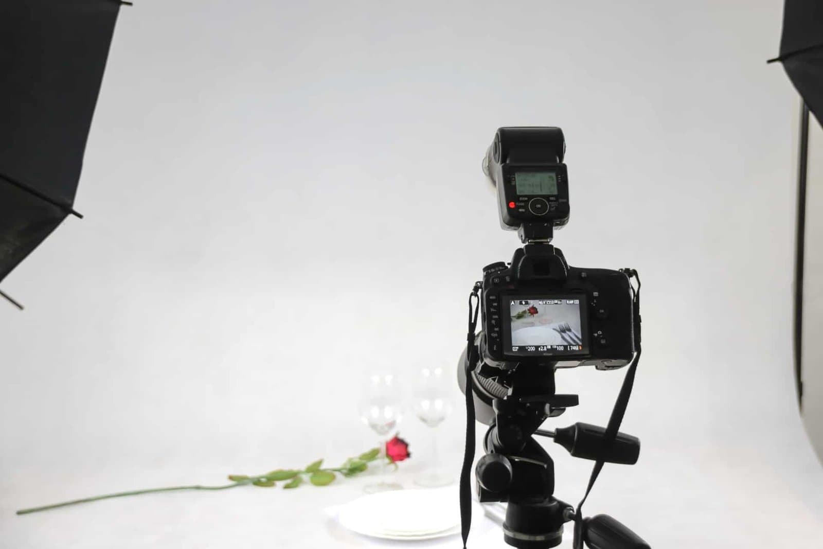 Studio lighting setup with softbox umbrellas and a camera on a tripod