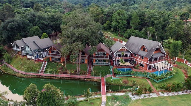 Aerial view of riverside resort villas surrounded by forest